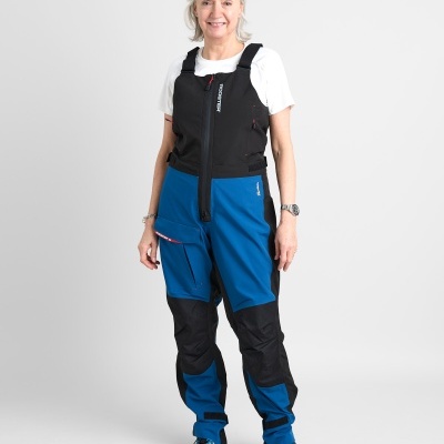 Mulher com fato de proteção outdoor azul e preto, em fundo branco