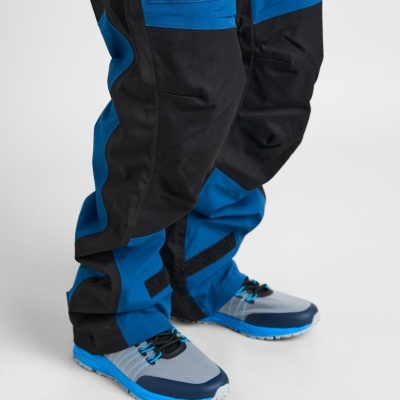 Calças de trabalho azuis e pretas com sapatilhas desportivas cinza e azul