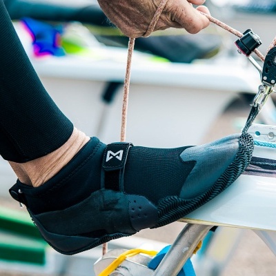 Pé com sapato neoprene preto e meia preta em equipamento náutico
