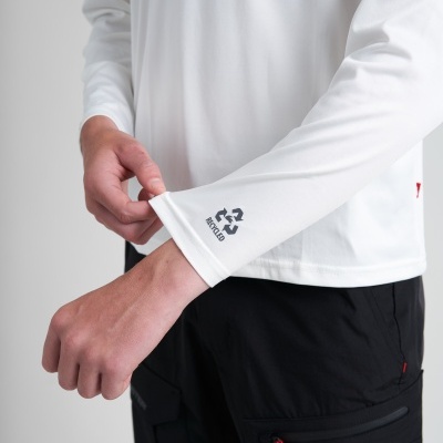 Manga de camisa branca com símbolo de reciclagem e calças pretas com bolsos com zíper vermelho