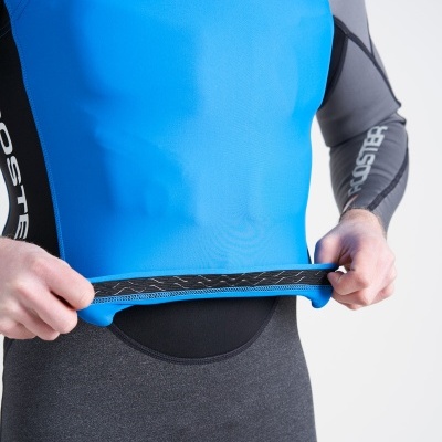 Colete de neopreno azul e preto com marca Rooster, ajustado por pessoa com mangas cinzentas