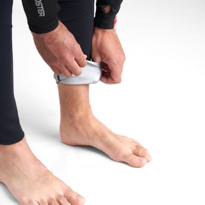 Pernas com leggings pretas ROOSTER com uma mão a enrolar a bainha para revelar interior cinza claro