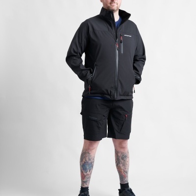 Homem com jaqueta preta, shorts pretos e ténis escuros em fundo branco