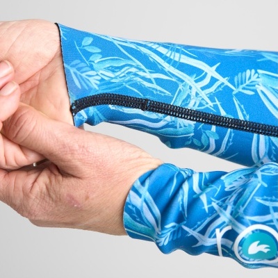 Mangas azuis com padrão de folhas e fecho preto, em fundo cinza