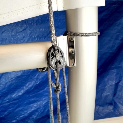 Mastro de vela branco com cordas cinzentas e polias preto e alumínio com fundo azul