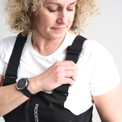 Pessoa vestindo macacão preto com tiras ajustáveis e texto ROOSTER