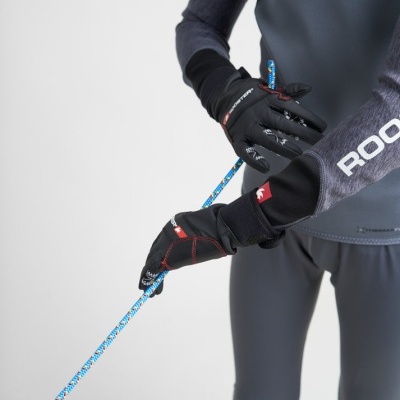 Pessoa a usar roupa desportiva e luvas ROOSTER segurando uma corda azul com padrão.