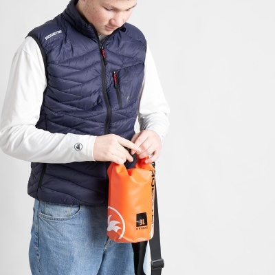 Pessoa a vestir colete azul escuro e a segurar bolsa impermeável laranja 3L