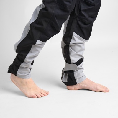 Calças desportivas pretas e cinzentas com bracelete no tornozelo, usadas por pessoa descalça