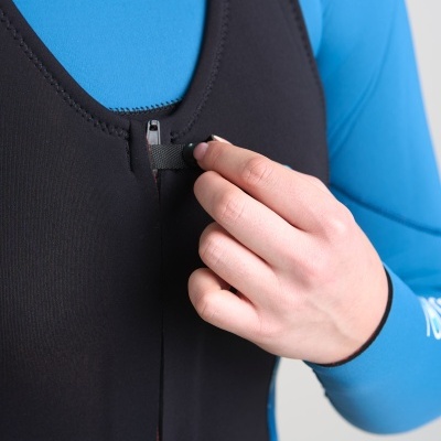 Pessoa vestindo fato de neoprene preto e azul, com mão segurando o fecho de correr na frente