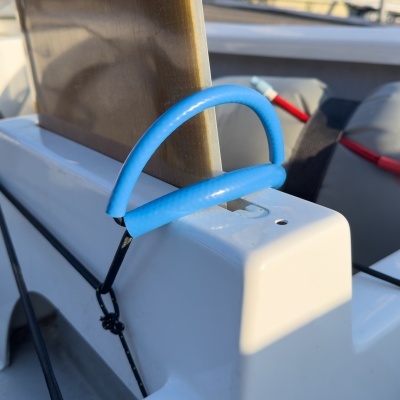 Corda elástica azul em alça presa em superfície branca de barco