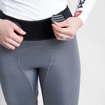 Pessoa a vestir calças justas cinzentas com cinto preto ajustável