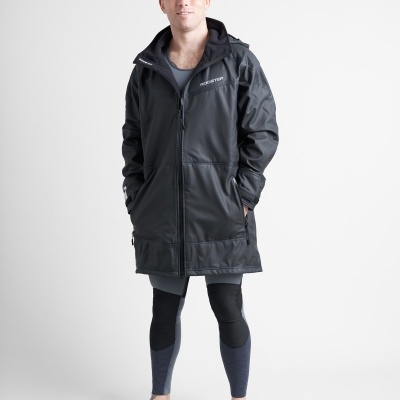 Homem com casaco impermeável preto e calças desportivas em fundo branco