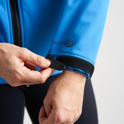Pessoa a ajustar a manga de casaco Softshell azul com velcro preto