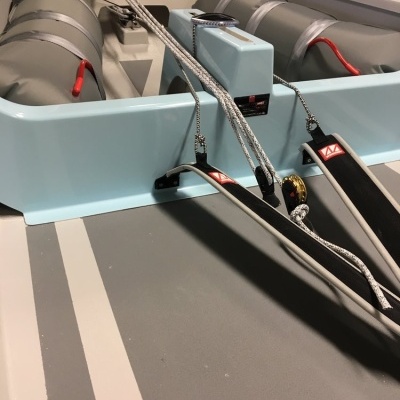 Barco insuflável cinzento e branco com cabos e tubos para os pés com etiquetas vermelhas M