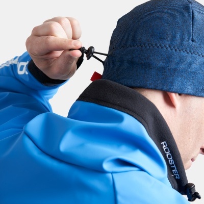 Homem a usar chapéu azul escuro com cordão e casaco azul com gola preta e texto ROOSTER