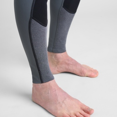 Leggings de desporto cinzentas e pretas com pés descalços sobre fundo cinzento claro