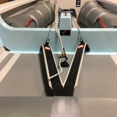 Barco pequeno de recreio com infláveis cinzentos e casco azul claro em ambiente interior