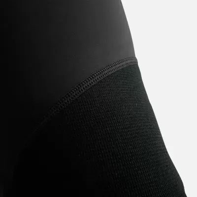 Peça de vestuário preta com tecidos lisos e texturizados e costura visível