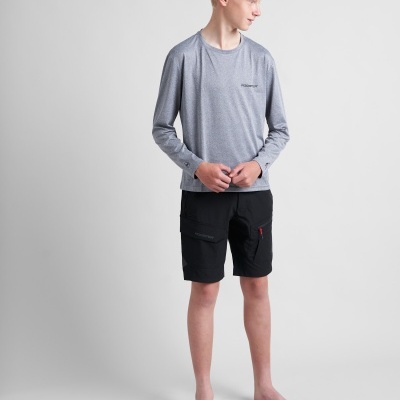 Jovem com t-shirt cinzenta de manga comprida e calções pretos em fundo cinzento.