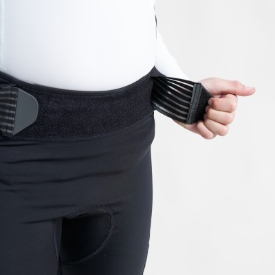 Pessoa vestindo calças pretas ajustando faixa elástica na cintura