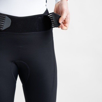 Calças justas pretas com cinto largo elástico preto preso por uma mão
