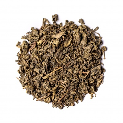 Chá verde seco em folhas soltas sobre fundo branco