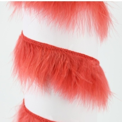 Fitas vermelhas de tecido e penas decorativas em suporte branco