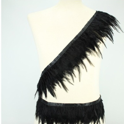 Fita preta com penas e bordas de cetim num manequim branco