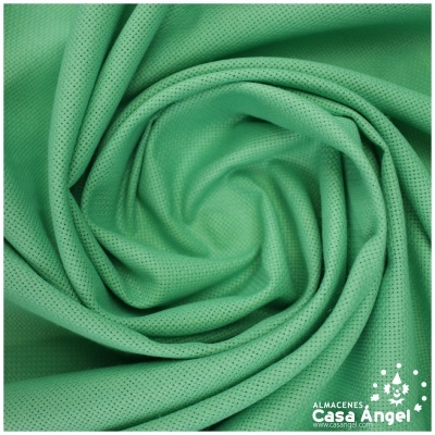Tecido verde claro com textura de microfuros enrolado em forma de caracol