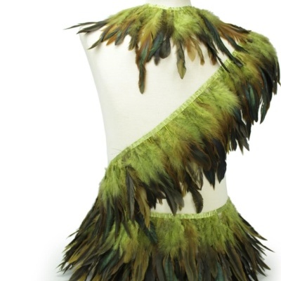 Conjunto de vestuário com penas verdes e castanhas exibido num manequim branco