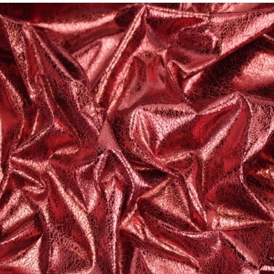 Tecido vermelho metálico brilhante com dobras e textura rugosa