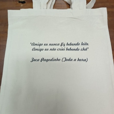Saco de tecido branco com texto preto impresso, alças largas