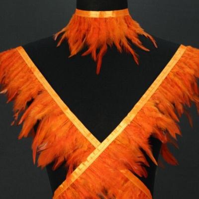 Conjunto de penas laranja com fitas em manequim preto