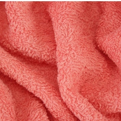 Tecido felpudo cor de coral com textura macia e dobrada