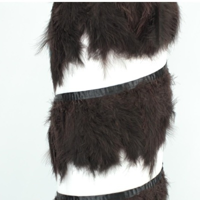 Tecido decorativo com franjas de pelo castanho escuro e faixas pretas num fundo branco