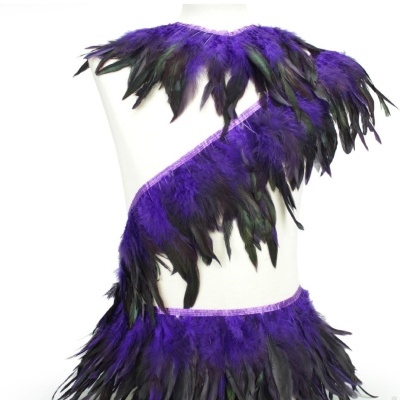 Traje decorativo de penas roxas e pretas em manequim branco