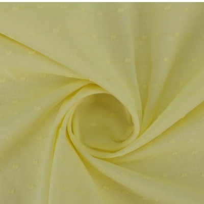 Tecido amarelo claro com textura e padrão de pequenos desenhos enrolado no centro