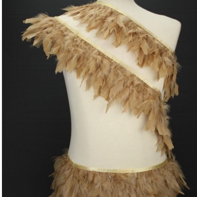 Faixa decorativa de plumas castanhas e bege num manequim branco