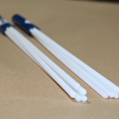 Dois pares de pauzinhos chineses brancos em fundo bege