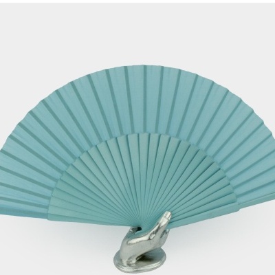 Leque azul claro em tecido apoiado em mão metálica prateada