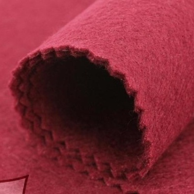 Rolo de tecido vermelho com textura felpuda e borde recortado