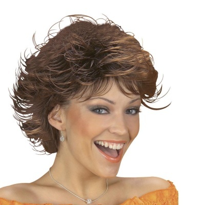 Mulher sorridente com cabelo castanho curto e ondulado, vestido laranja e acessórios prateados