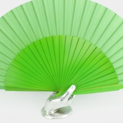 Leque de mão verde em mão decorativa metálica prateada.