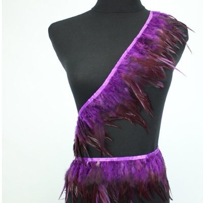Fita decorativa com penas roxas e lilás numa manequim preta