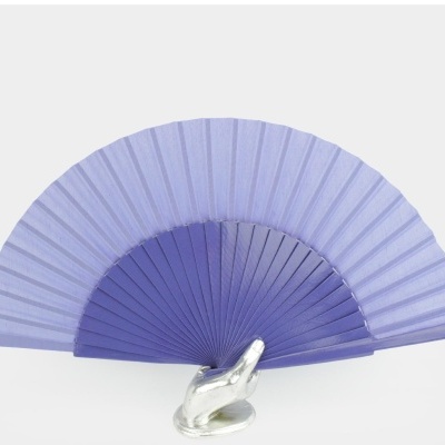 Leque lilás com guarda roxa segurado por mão decorativa branca.