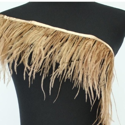 Adereço de pena castanha clara numa fita bege sobre manequim preto