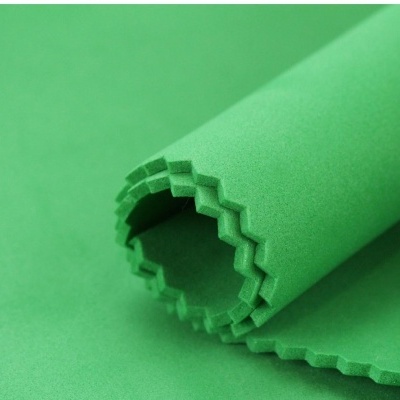 Tecido verde de algodão com bordas picotadas enrolado.