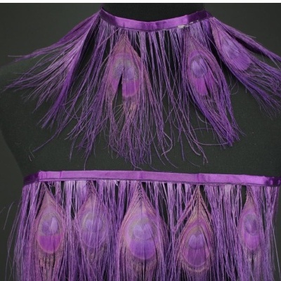 Franja decorativa roxa com penas longas e padrão de olho de pavão