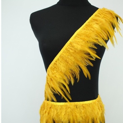 Faixa amarela com penas em diagonal sobre manequim preto